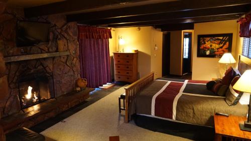 1 dormitorio con 1 cama y chimenea de piedra en Lodge at Sedona en Sedona