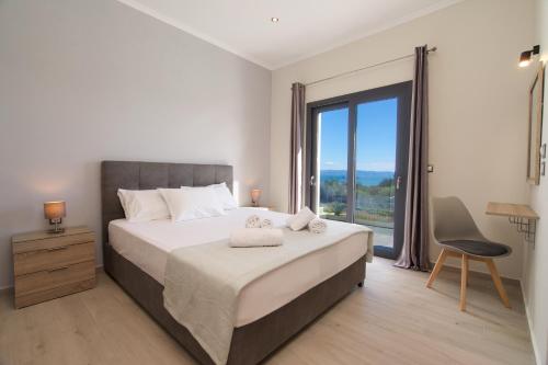 a bedroom with a bed and a large window at Vista Blu Villa in Vlachata