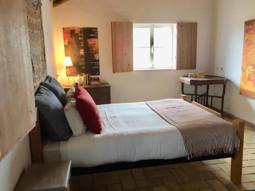 a small bedroom with a bed with a window at Casa da Pedra Azul in Santo Estêvão