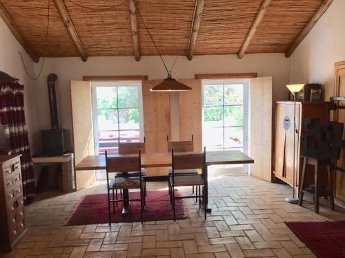 a dining room with a table and chairs and windows at Casa da Pedra Azul in Santo Estêvão