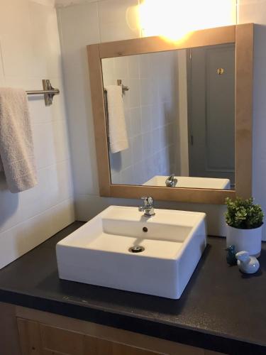 a bathroom with a white sink and a mirror at Casa da Pedra Azul in Santo Estêvão