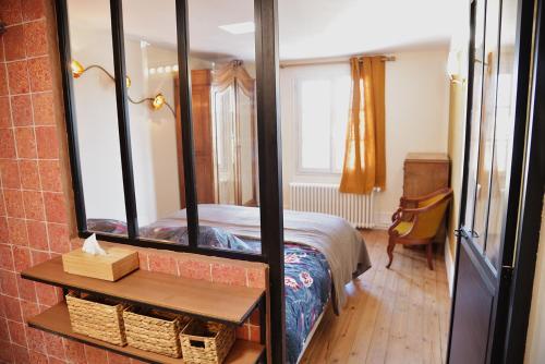 1 dormitorio con cama y espejo grande en Gîte de l'Écu, en La Roche-Guyon