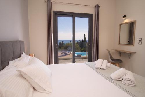 a bedroom with a bed with a view of the ocean at Vista Blu Villa in Vlachata