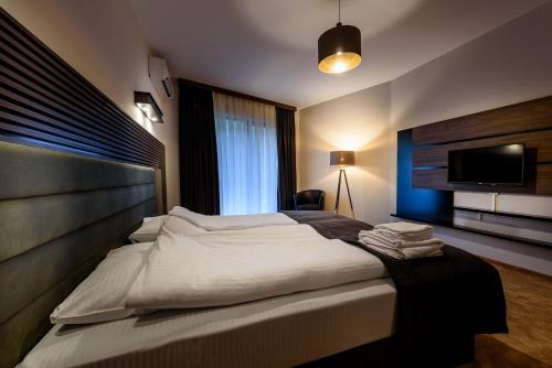 a bedroom with a large bed and a flat screen tv at Resort Ujevara e Drinit in Peje