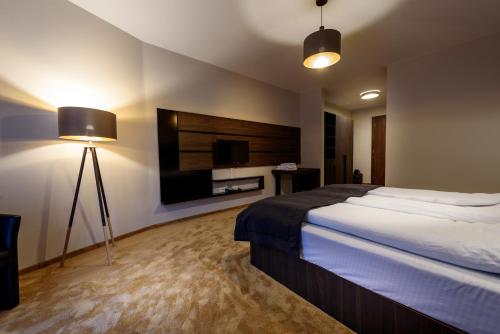 a hotel room with a bed and a flat screen tv at Resort Ujevara e Drinit in Peje