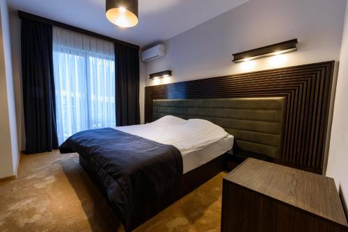a bedroom with a bed and a large window at Resort Ujevara e Drinit in Peje