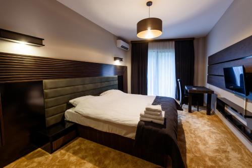 a bedroom with a bed and a flat screen tv at Resort Ujevara e Drinit in Peje
