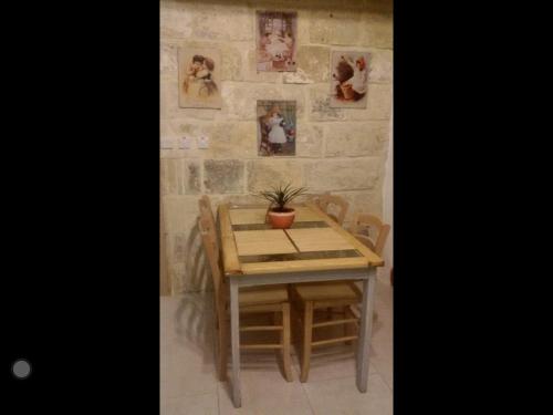 a wooden table with a potted plant on a wall at Amelia's House of Character in Cospicua
