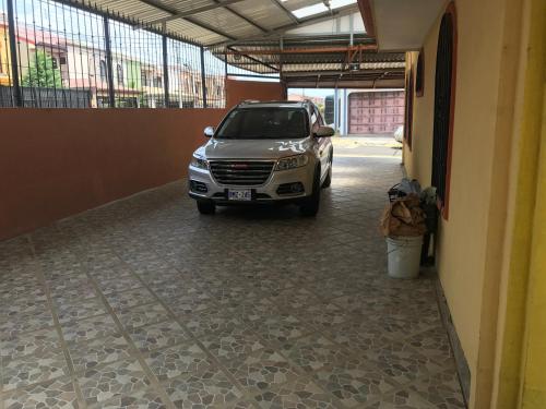 a car parked in a parking lot next to a building at Casa del Suizo in Alajuela City