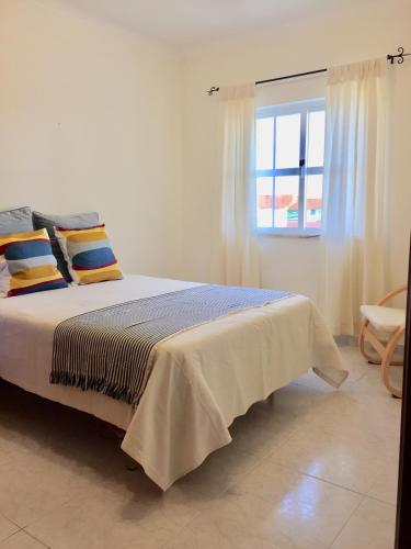 a bedroom with a large bed with a window at Lagos Beach Villa in Lagos