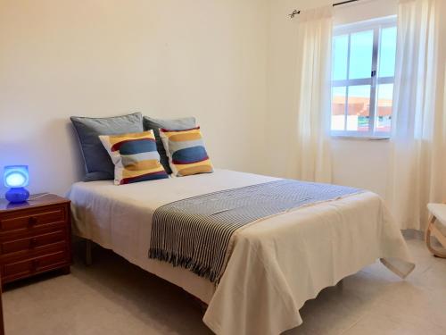 a bedroom with a bed with pillows and a window at Lagos Beach Villa in Lagos