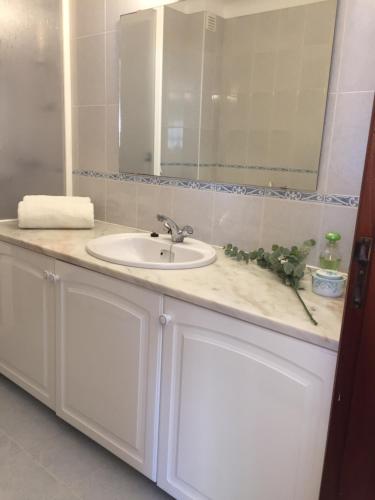 a bathroom counter with a sink and a mirror at Lagos Beach Villa in Lagos