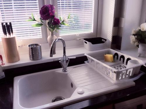 - un évier de cuisine avec un étendoir à vaisselle à côté d'une fenêtre dans l'établissement Bexleyheath Town Centre Four bedrooms, Five Beds House, à Bexleyheath