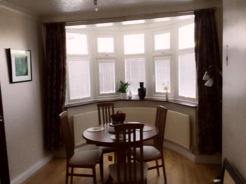 a dining room with a table and chairs and a window at Bexleyheath Town Centre Four bedrooms, Five Beds House in Bexleyheath