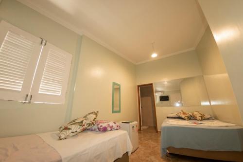 a bedroom with two beds and a mirror at Recanto do Aconchego in Porto De Galinhas