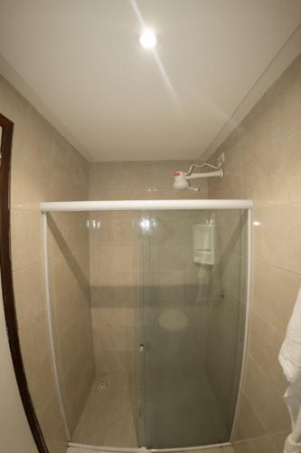 a shower with a glass door in a bathroom at Recanto do Aconchego in Porto De Galinhas