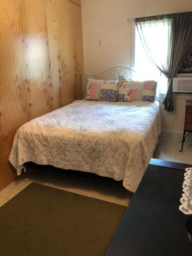 1 dormitorio con 1 cama grande y ventana en Ohana Pua Hale, en Kailua-Kona