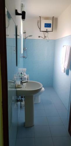 Baño blanco con lavabo y espejo en Acquabey Surf Villa, en Matara