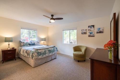 - une chambre avec un lit, une chaise et des fenêtres dans l'établissement Mauna Nani, à Volcano