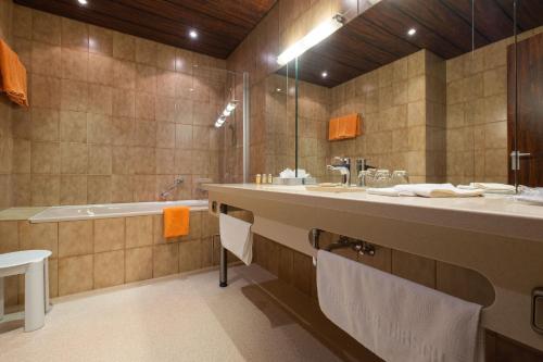 bagno con grande lavandino e vasca di Hotel Goldener Hirsch a Bayreuth