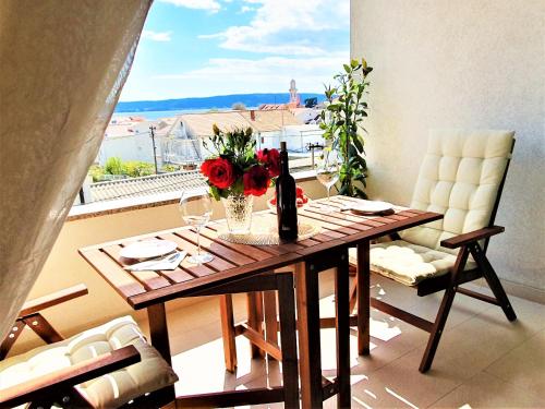 a dining room table with a vase of flowers on it at Hygge Apartments top location Kaštel Lukšić / Split in Kaštela