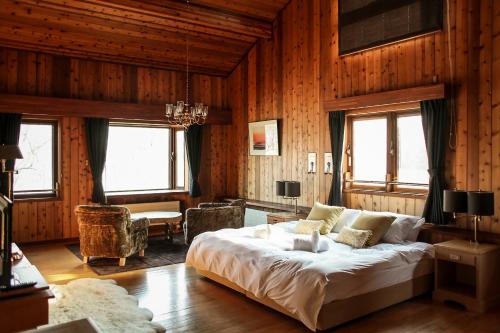 1 dormitorio con 1 cama grande en una habitación con paredes de madera en Lakehouse At Toyako, en Lago Toya