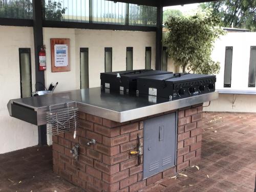 a outdoor grill with four burners on a brick counter at Bayview Motel in Esperance