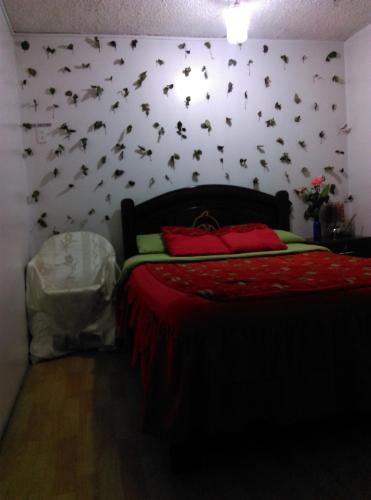 1 dormitorio con 1 cama con murciélagos en la pared en Escocie - Quito, en Quito