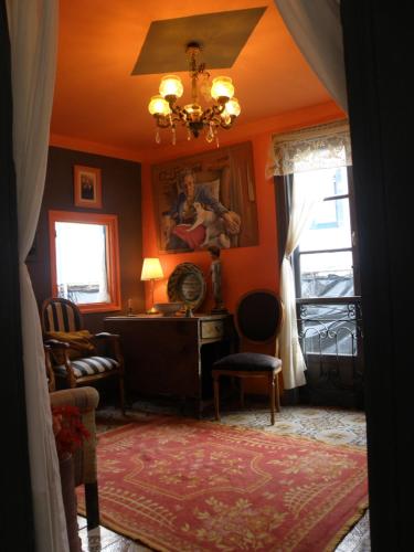 a living room with orange walls and a chandelier at The Old Palace Tower / La Torre del Palación in Cudillero