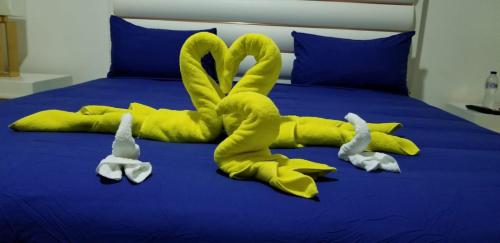 ein Bett mit zwei Schwänen aus Handtüchern in der Unterkunft Villa de Colores 3 Rooms 5 king Beds in Sosúa