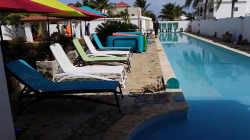 un grupo de sillas sentadas junto a una piscina en Villa de Colores 3 Rooms 5 king Beds, en Sosúa