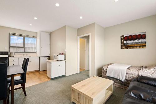 a living room with a couch and a table at Econo Lodge Canterbury Court Motel in Christchurch