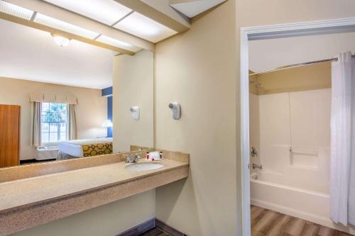 a bathroom with a sink and a mirror at Baymont by Wyndham Jacksonville/Butler Blvd in Jacksonville