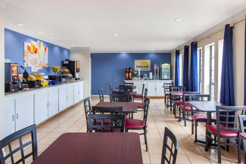 ElmendorfにあるDays Inn & Suites by Wyndham Braunig Lakeのレストラン内のテーブルと椅子のあるダイニングルーム