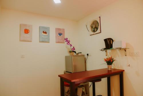 a room with a desk and a refrigerator and a table at Yellow Cube at Lumut Cube Homestay Kontena in Lumut