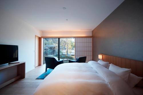 a hotel room with a large bed and a large window at Aoi Suites at Nanzenji Modern & Traditional Japanese Style in Kyoto