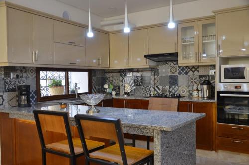 uma cozinha com armários de madeira e um balcão de granito em Sabat em Mahdia