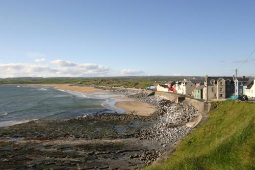 a view of a beach with houses and the ocean at Vaughan Lodge Hotel in Lahinch