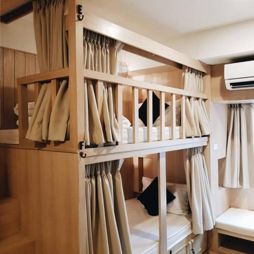 a bunk bed with curtains in a room at Amaka Bed and Breakfast in Chiang Mai