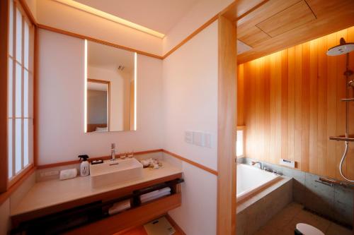 ein Badezimmer mit einem Waschbecken und einer Badewanne in der Unterkunft Aoi Suites at Nanzenji Modern & Traditional Japanese Style in Kyoto