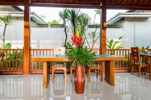 a wooden table with a vase with flowers on a porch at The Pesaren Ubud in Ubud