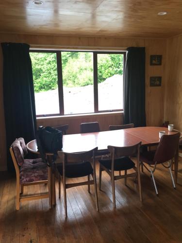 a table and chairs in a room with a large window at Mount Cook Station Shearers Quarters Lodge in Lake Tekapo