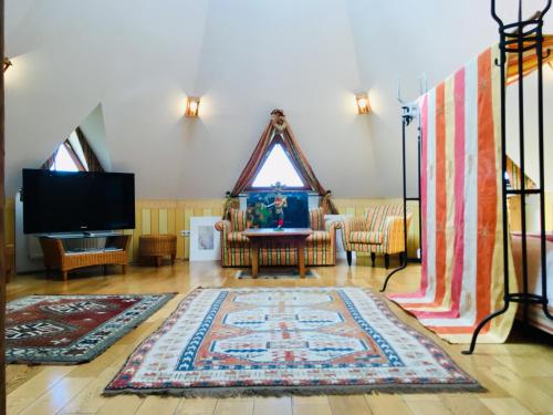 a living room with a tv and a rug at Villa EdelStein in Loipersdorf bei Fürstenfeld