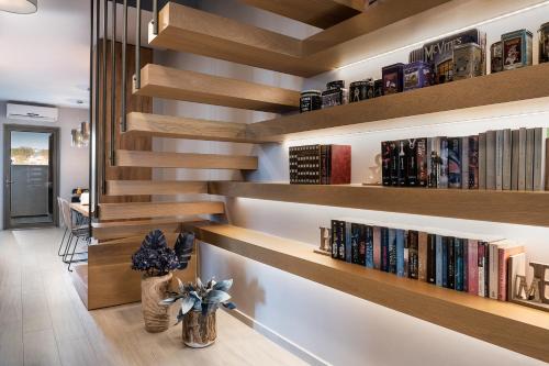 a library with wooden shelves with books at Ciel Collection Suites in Chania Town