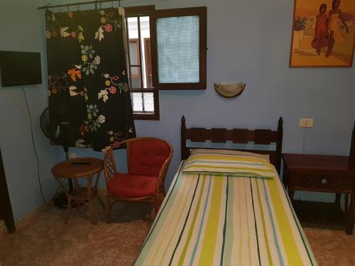 a room with a bed, chair, table and window at Hostal 7 Soles in Las Palmas de Gran Canaria