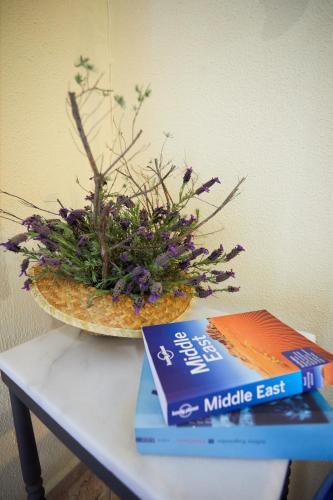 a bowl of flowers sitting on a table with a book at Zorbas Apartments in Volissos