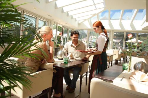 a group of people sitting at a table in a restaurant at Biohotel Leutascherhof in Leutasch