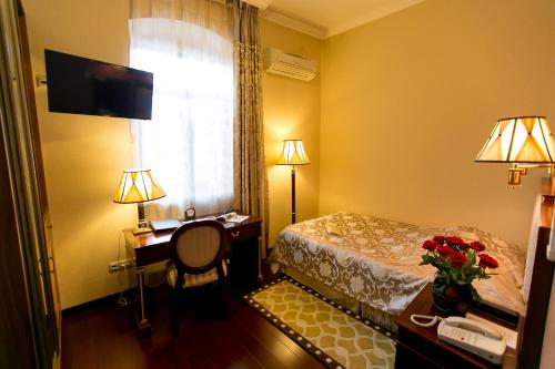 a hotel room with a bed and a desk and a window at AllureInn Hotel and Spa in Chernivtsi