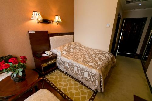 a hotel room with a bed and a table with flowers at AllureInn Hotel and Spa in Chernivtsi