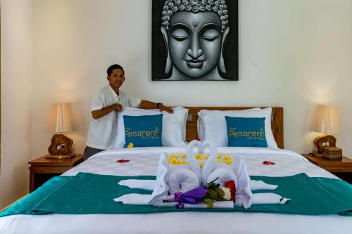 a man standing in front of a bed with a statue at The Pesaren Ubud in Ubud
